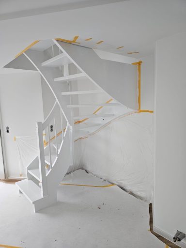 Blick auf eine unvollendete Treppe mit weißen Stufen und gelber Markierung.