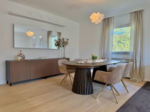 Helles Esszimmer mit runder Tischanlage, gepolsterten Stühlen und modernem Dekor.