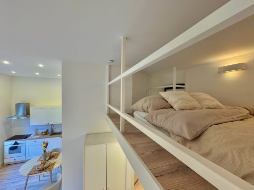 Gemütliches Loft mit Schlafbereich über offenem Wohnraum und moderner Küche.