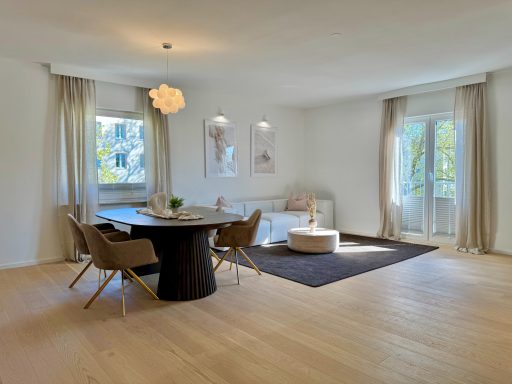 Heller, moderner Wohnraum mit Essbereich, Beige- und Grautönen, Balkonzugang.